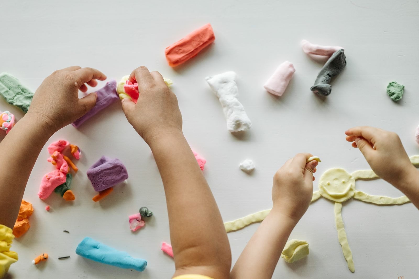 Little hands making colourful clay creations
